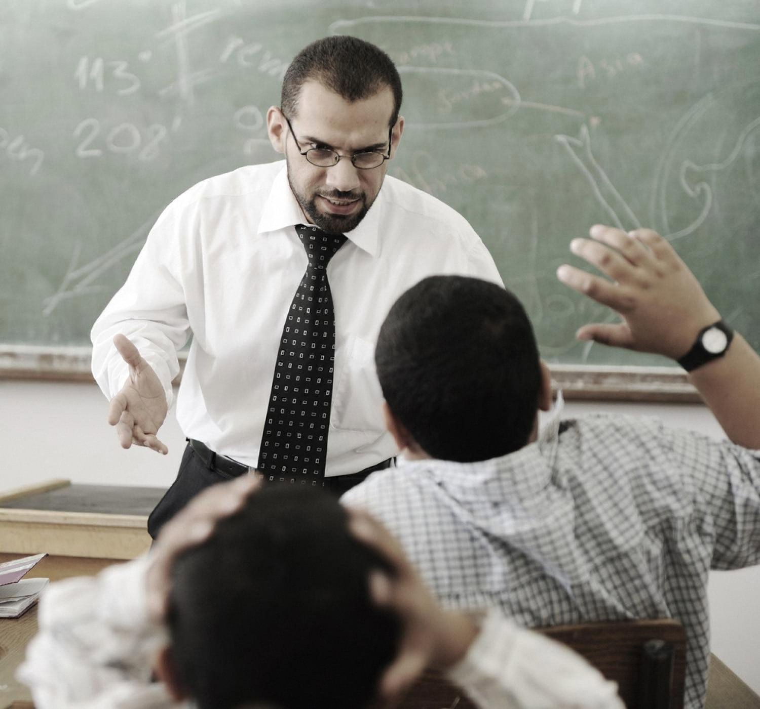 A teacher in a UAE classroom explaining a lesson to attentive young students